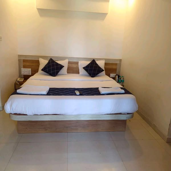 The Tranquil Terrace room with a bed dressed in white linen and navy cushions